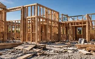 Wood-framed house under construction with scrap lumber on the ground